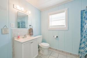 a bathroom with a toilet and a sink and a window at Beach lovers dream come true walking distance to the sandy shores in Galveston +46 photos