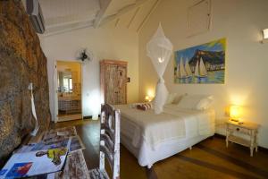a bedroom with a bed and a table in a room at Casa da Ilha & SPA in Abraão