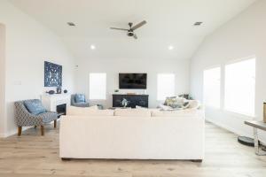 a living room with a white couch and a fireplace at Get ready to soak up the sun at Villa Caman in Galveston