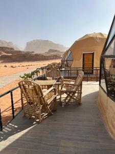 a patio with chairs and tables and tents in the desert at Moon Dunes Wadi Rum in Disah