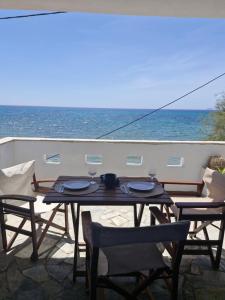 a patio with a table and chairs and the ocean at Thalias apartments in Kómi