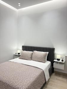 a white bedroom with a large bed with pillows at MariAnthi Apartment in Kremasti
