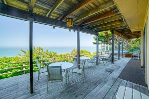 a deck with tables and chairs and a view of the ocean at Oceanfront Irish Beach Home Private Beach Access! in Manchester