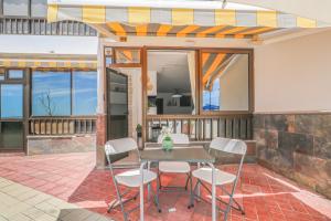 a patio with a table and white chairs at Endless Seaview Patalavaca in Patalavaca