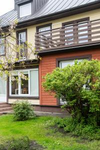 a house with windows and bushes in front of it at Ema in Palanga