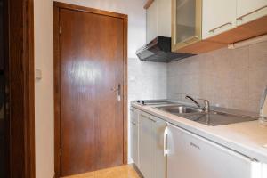 a kitchen with a sink and a wooden door at Apartments Niki in Brela