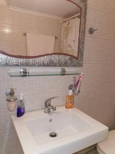 un bagno con un lavandino bianco e uno specchio di Markou Mpotsari 19 & Hras, Perigiali , Korinthias a Kórinthos Altre 5 foto