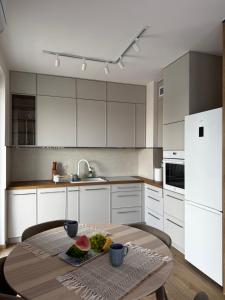 una cocina con armarios blancos y una mesa con fruta. en APARTAMENT przy Tężni Busko Zdrój, en Busko-Zdrój