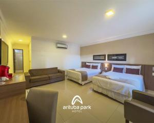 a hotel room with two beds and a couch at Arituba Park Hotel in Natal