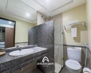 a bathroom with a sink and a toilet and a mirror at Arituba Park Hotel in Natal