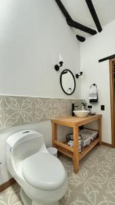 Un baño con un inodoro blanco y un lavabo. en Casa La Eugenia - a 3 cuadras de la Plaza de Villa de Leyva, en Villa de Leyva