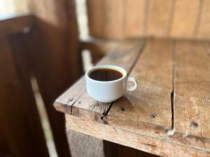 a cup of coffee sitting on a wooden table at ALPHINA CABINS Qhapaq Ñan in Sahuayacu