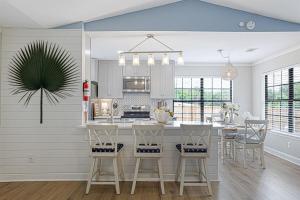 eine Küche mit weißen Schränken und einem Tisch mit Stühlen in der Unterkunft Gritz & Giggles, Where Southern Charm Meets Belly Laughs in Port Royal
