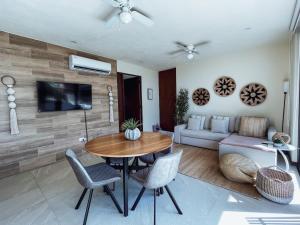 a living room with a table and a couch at Sunrise 2BR Apt Steps from the Beach with Pool View in Holbox Island