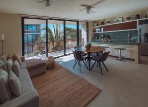 a living room with a couch and a table with chairs at Sunrise 2BR Apt Steps from the Beach with Pool View in Holbox Island