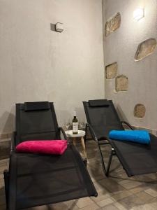 two black chairs and a table with a bottle of wine at Apartman u srcu antičke Pule in Pula