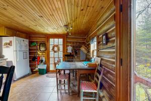 Una cocina y un comedor con una mesa y un refrigerador. en Authentic Maine Log Cabin, en Greenville 19 fotos más