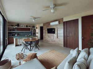 a living room with a couch and a table at Sunset 2BR Apartment Steps from the Beach with Ocean View in Holbox Island