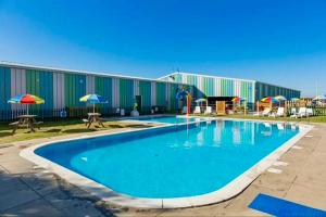 a large swimming pool in front of a building at Family Holiday Home with private terrace in Saint Osyth