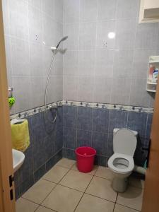 uma casa de banho com um WC e um balde vermelho em Alura em Martil