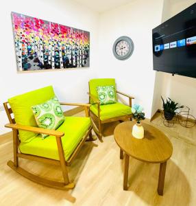 a living room with two green chairs and a table at Chic full apt in Heart of City in Panama City