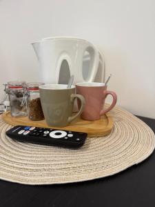 three coffee cups and a remote control on a table at Lawa in Wrocław