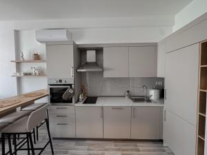 a kitchen with white cabinets and a table and chairs at Sal y Sol in Bar