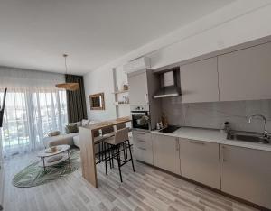 a kitchen with white cabinets and a table in a room at Sal y Sol in Bar