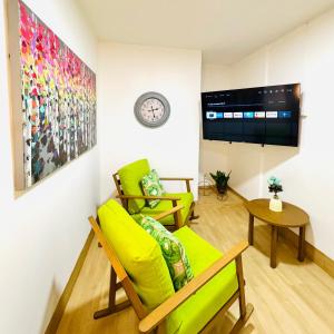 a living room with green furniture and a tv at Chic full apt in Heart of City in Panama City