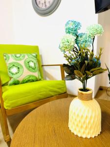 a living room with a table with a vase with flowers at Chic full apt in Heart of City in Panama City