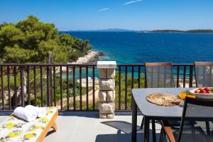 a table and chairs on a balcony with a view of the ocean at Apartments Doro in Vela Luka