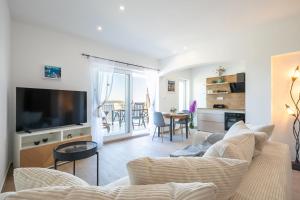 a living room with a couch and a tv at Apartments Doro in Vela Luka