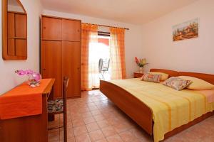 a bedroom with a bed and a table and a desk at Apartments Doro in Vela Luka