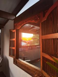 a window in a room with a view of the sunset at Pousada Casa de Cal y Canto in Penha +28 photos