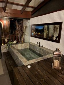 a bathroom with a large bath tub with a sink at Pousada Casa de Cal y Canto in Penha