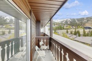 a balcony with two chairs and a view of the mountains at Red Cricket 22 in Sandpoint