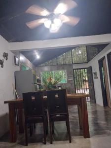 a dining room table with chairs and a ceiling fan at Happy Monkeys in Puerto Jiménez
