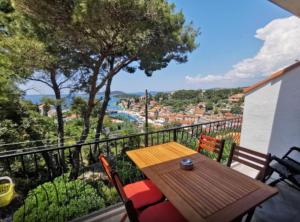 a wooden table and chairs on a balcony with a view at Apartments Vesna in Maslinica