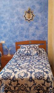 a bedroom with a bed with a blue wall at Casa el Alfar mudéjar in Teruel