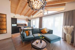a living room with a blue couch and a chandelier at Chalet Picave in Bad Elster