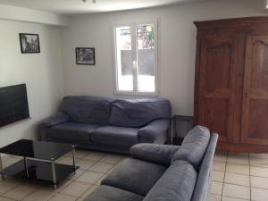 a living room with a couch and a tv at Le village caché in Le Mayet-de-Montagne