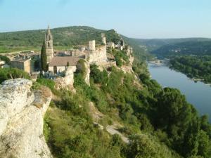a castle on top of a hill next to a river at Le nid de Marie in Saint-André-de-Roquepertuis +12 photos