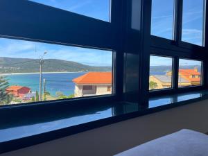 a room with a window with a view of the ocean at ENV Langosteira in Fisterra