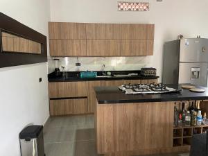 Una cocina con gabinetes de madera y encimera. en Villa Paulina, en Ebéjico