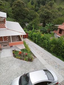 Un coche aparcado junto a una casa con jardín. en Villa Paulina, en Ebéjico