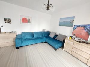 a blue couch in a living room with a tv at Villa Nautica in Luštica