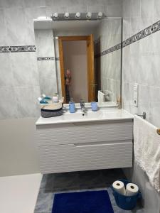 a bathroom with a sink and a large mirror at Monela Front beach sólo familias in Playa de Gandia