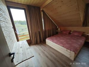 a bedroom with a bed and a large window at Vikendice Dream 1 in Sekulić 