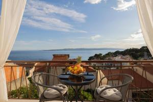 a table with a bowl of fruit on a balcony at Apartments Niki in Brela