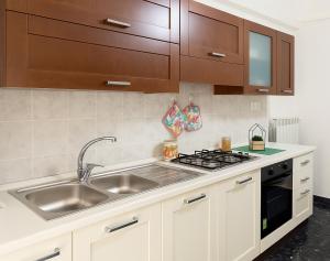 une cuisine avec un évier et une cuisinière dans l'établissement Domus Annae B&B, à Pompéi 25 autres photos